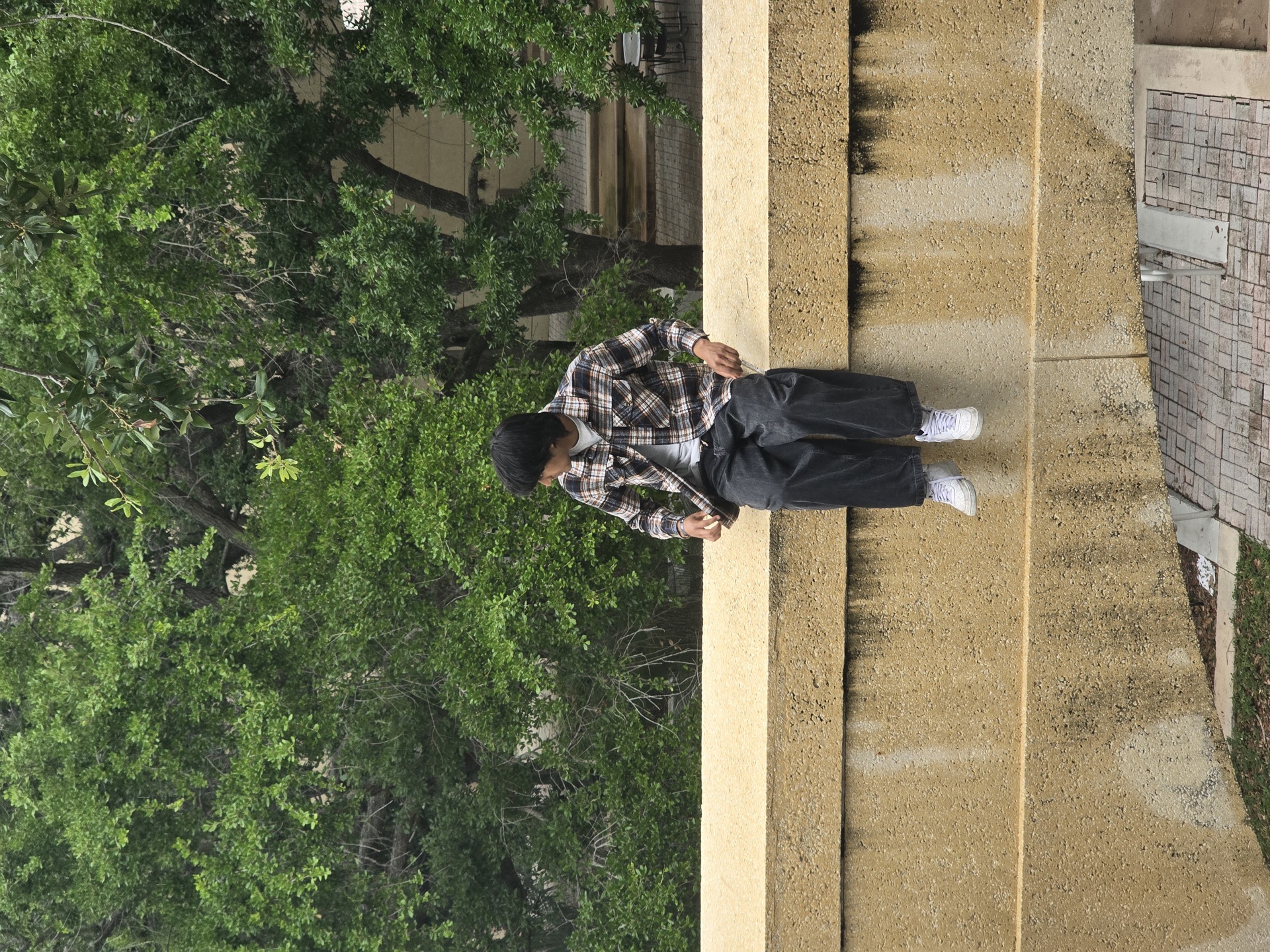Arshroop Saini sitting on a ledge in the park