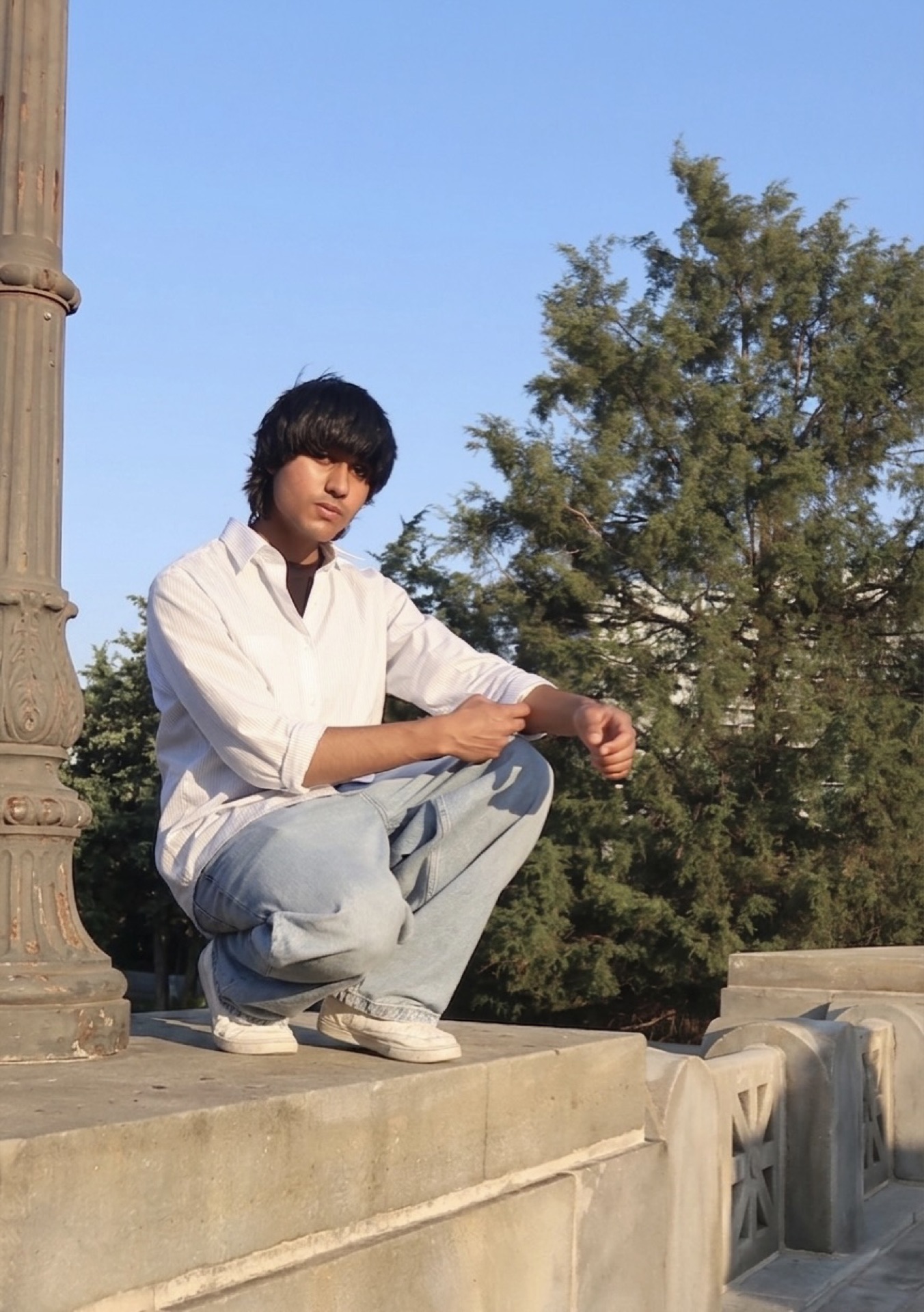 Arshroop Saini crouching outdoors at golden hour